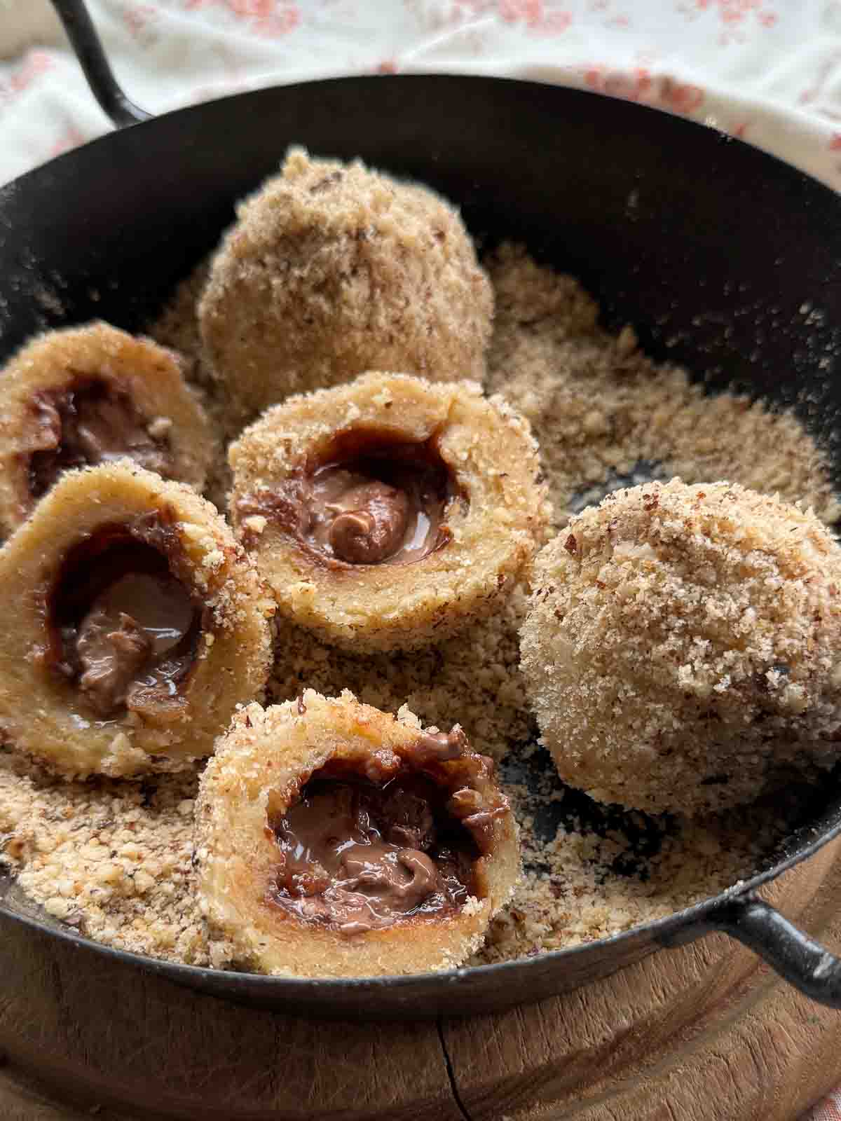 Nougatknödel aus Brandteig in Haselnussbröseln.