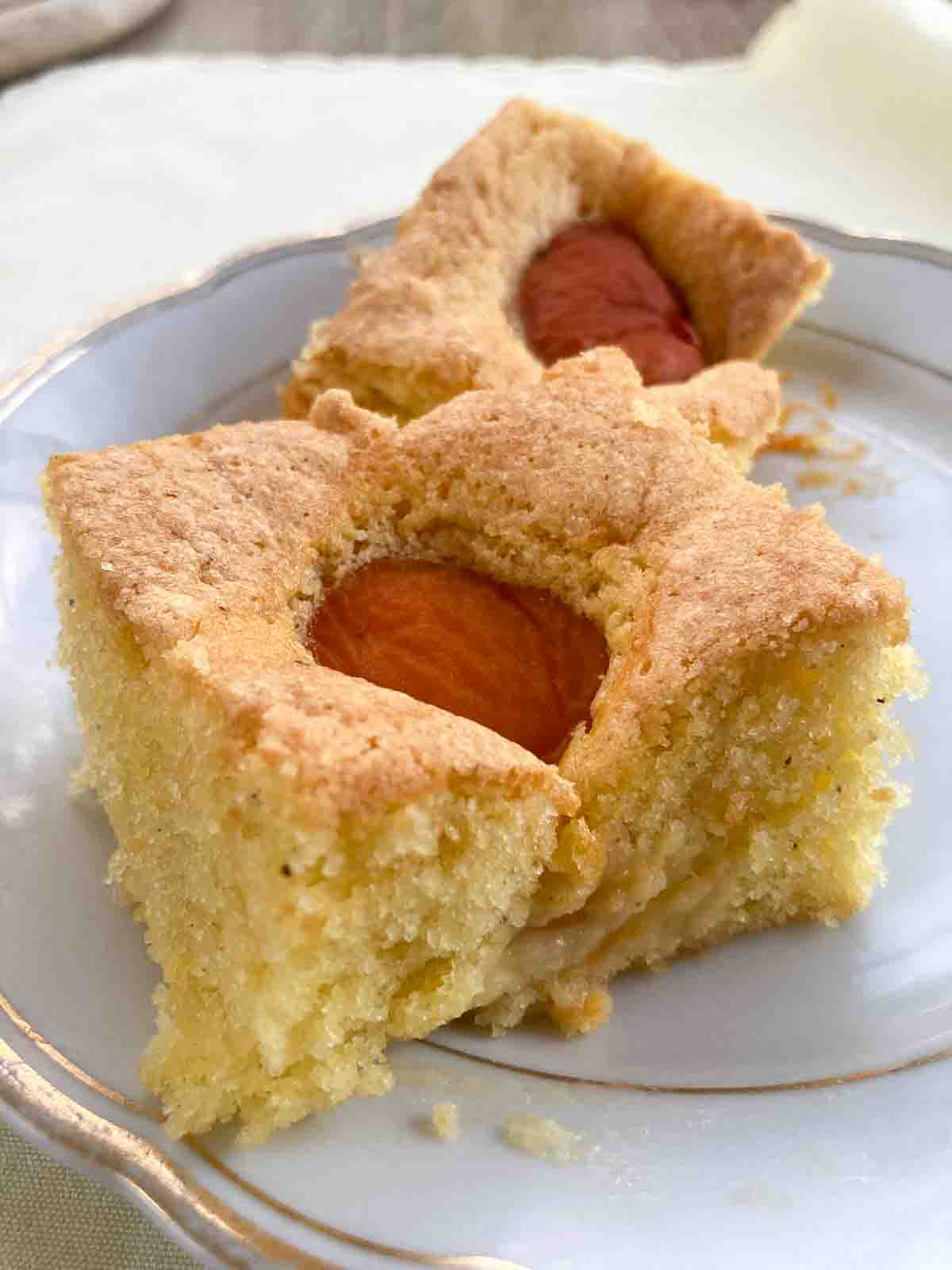 Sliced apricot cake on a porcelain plate.