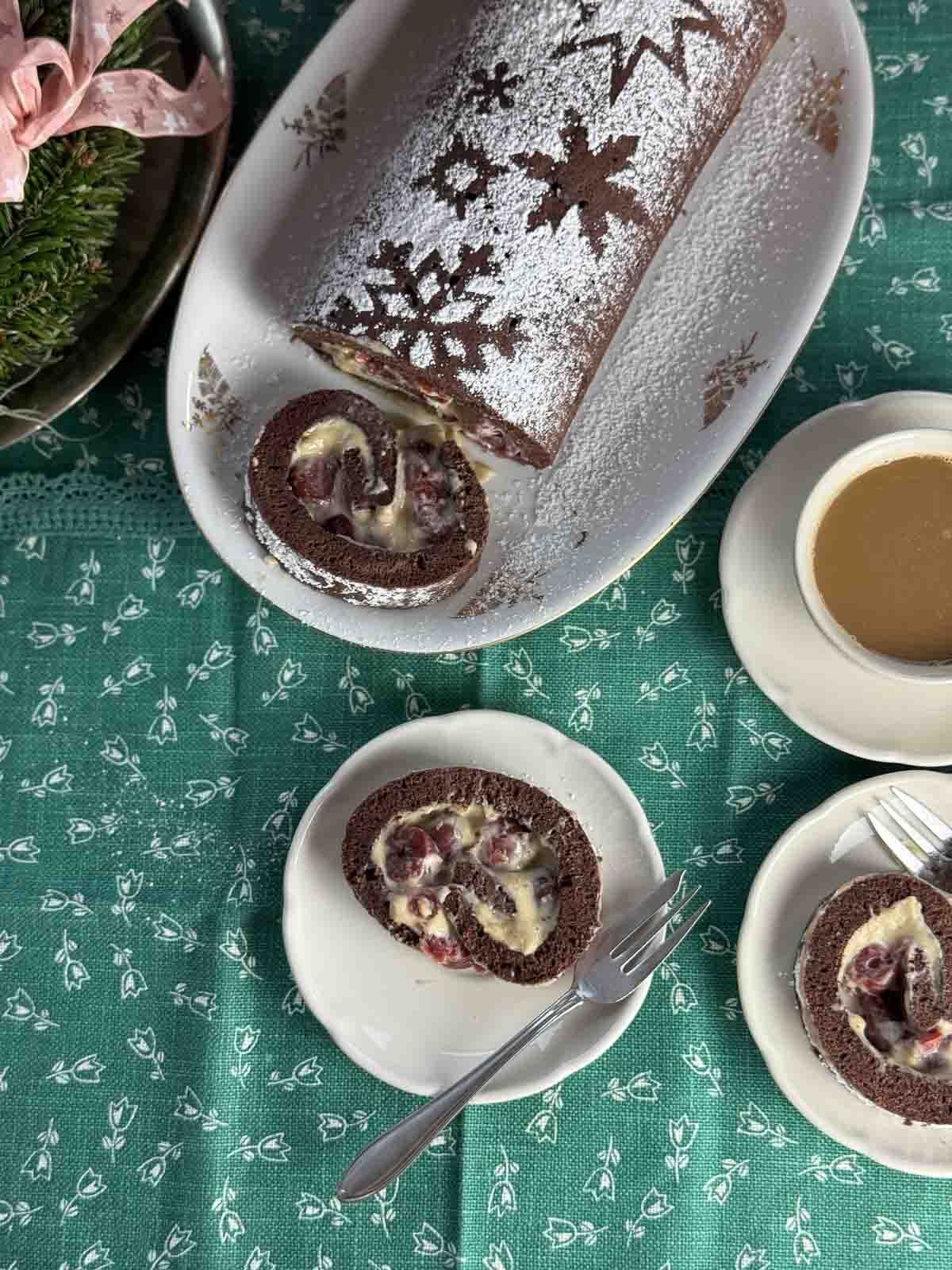 Dunkle Biskuitroulade mit Maronicreme, Weichseln und Schneesterne-Verzierung aus Staubzucker